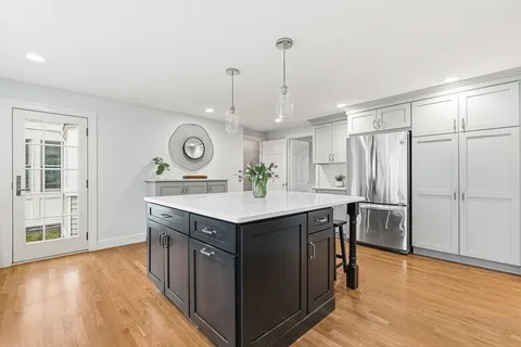 a kitchen with a sink a refrigerator and wooden floor