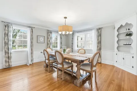 a dining room with furniture a chandelier and wooden floor