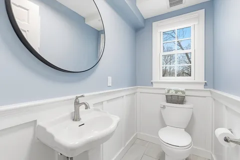 a bathroom with a sink a toilet and a mirror