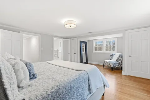 a spacious bedroom with a bed and wooden floor