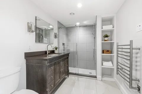 a bathroom with a granite countertop sink a toilet and shower
