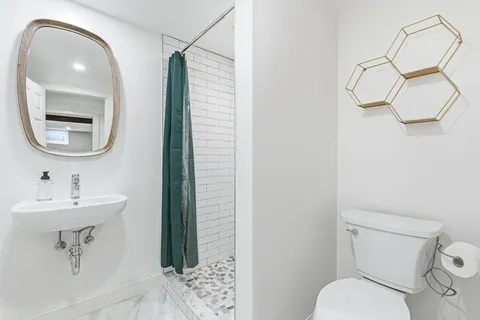 a bathroom with a toilet sink and mirror