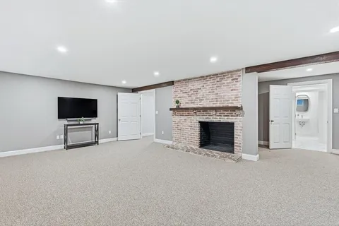 a view of an empty room with a fireplace and a window