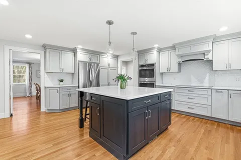 a kitchen with stainless steel appliances granite countertop a sink stove and wooden floor