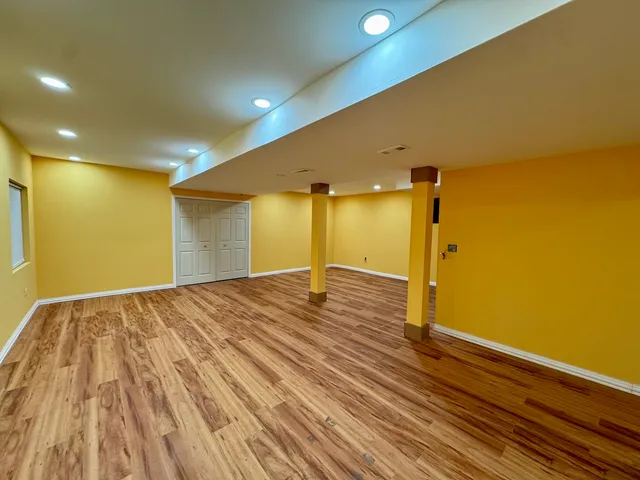 a view of empty room with wooden floor