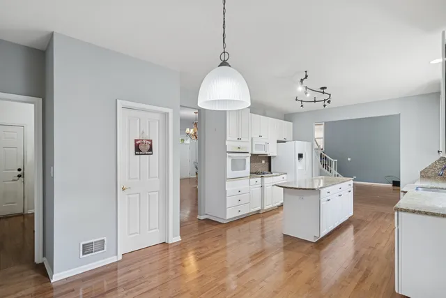 a living room with white cabinets and white appliances