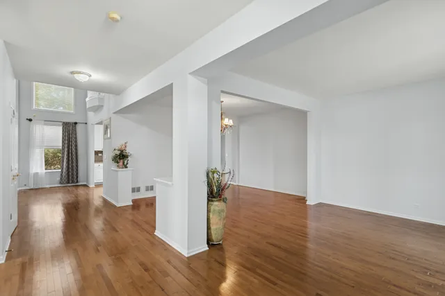 a view of a hallway with wooden floor and a living room