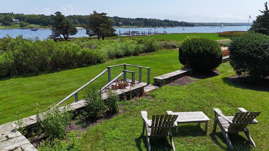 160 Allens Point Road Marion, MA 02738 - Photo 16 of 31 a view of a table and chairs with the garden in the background