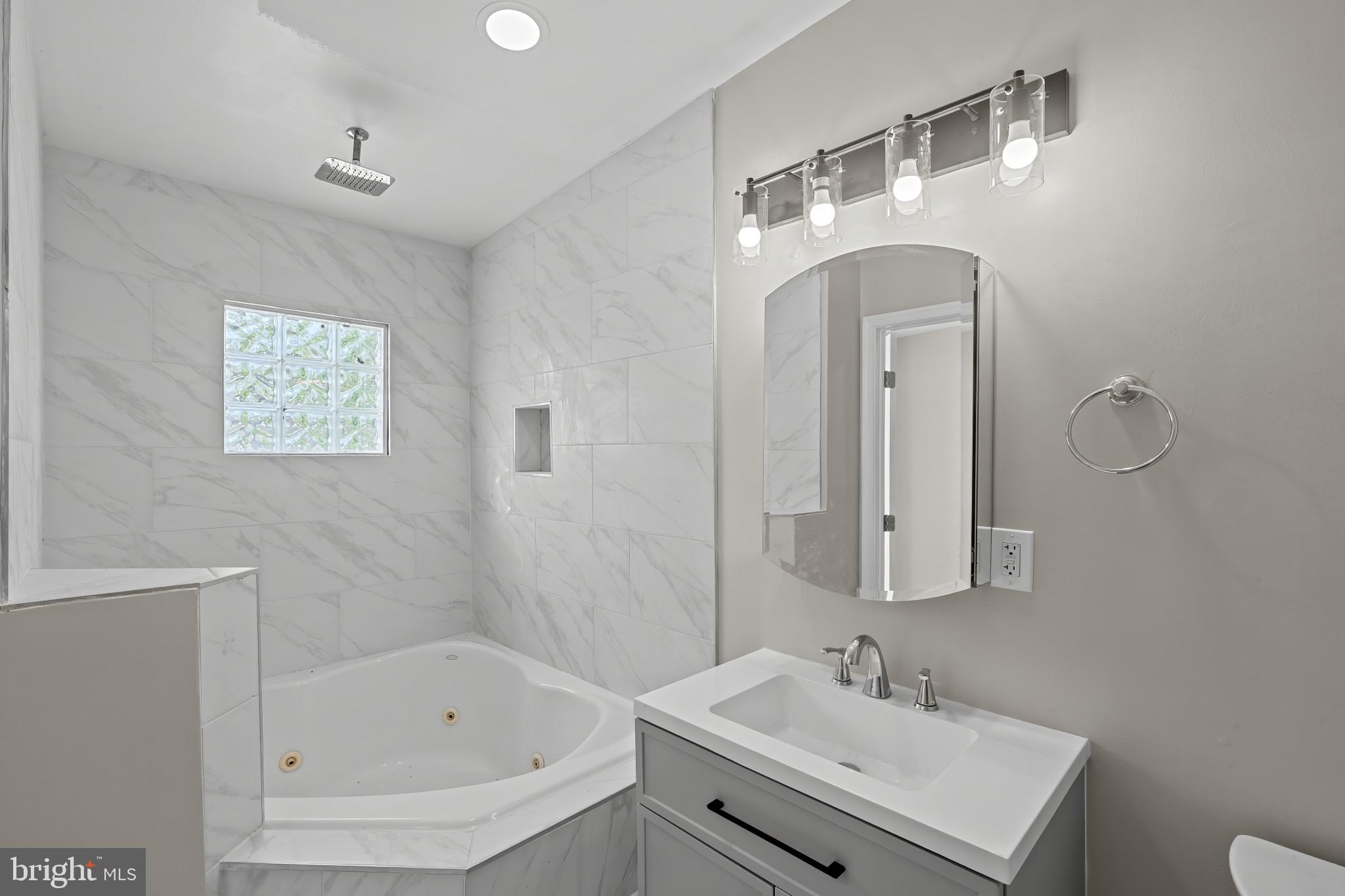1525 West Pratt Street Baltimore, MD 21223 - Photo 26 of 40 a bathroom with a sink a bathtub and a mirror