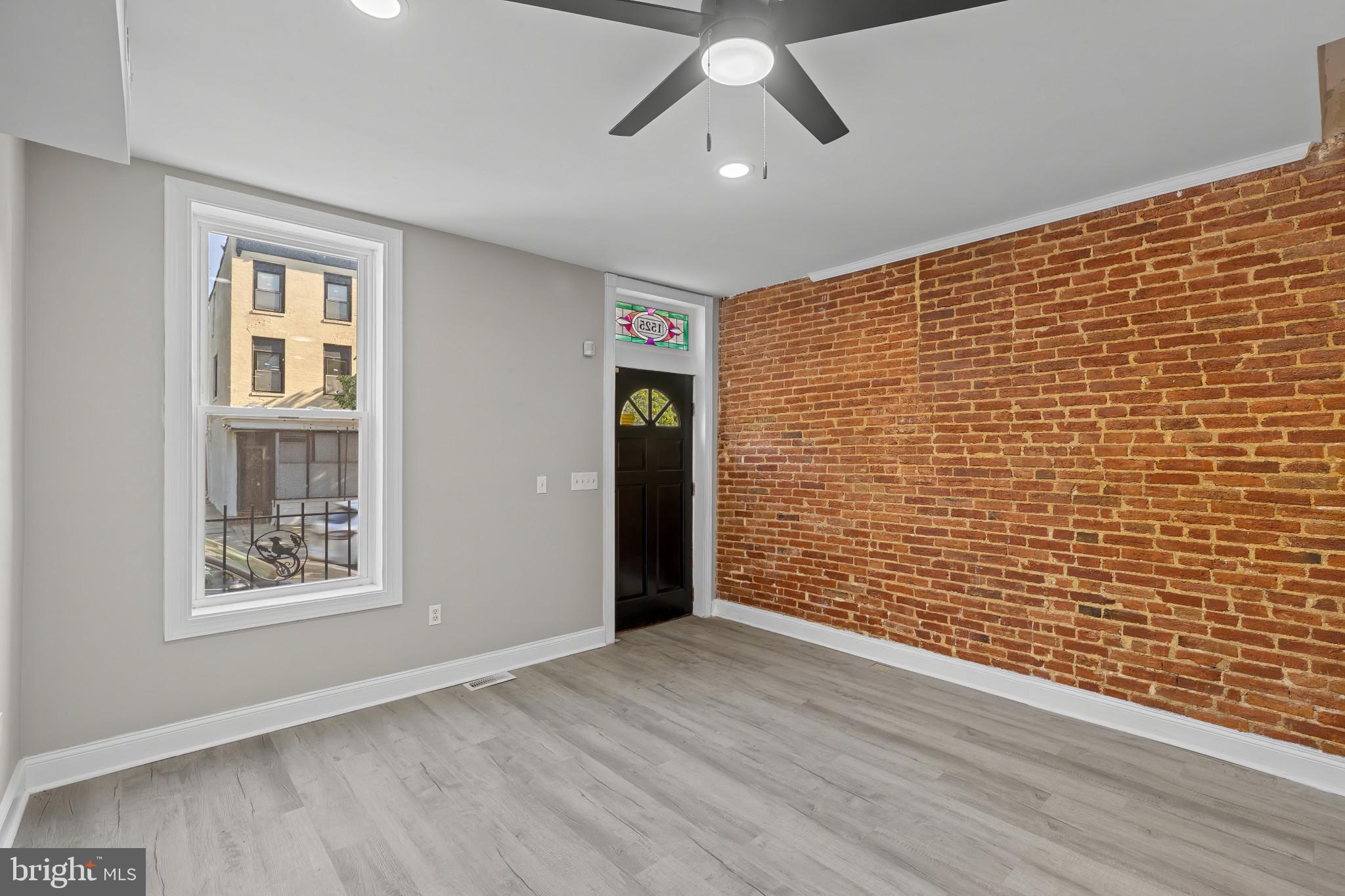 1525 West Pratt Street Baltimore, MD 21223 - Photo 4 of 40 a view of an empty room with wooden floor and a window