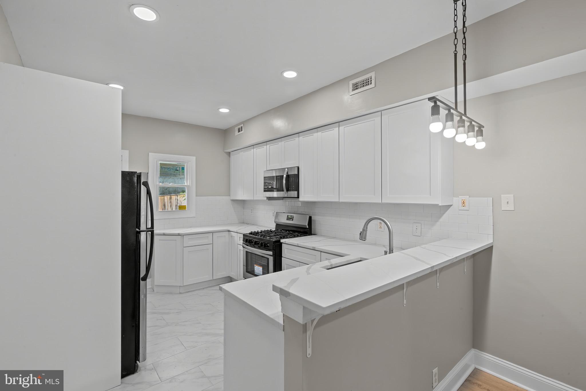 1525 West Pratt Street Baltimore, MD 21223 - Photo 7 of 40 a kitchen with stainless steel appliances a sink stove and refrigerator