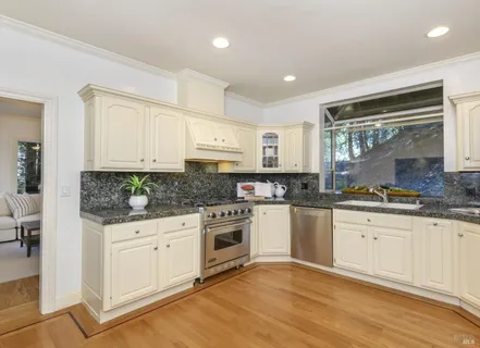 a spacious bathroom with a granite countertop sink a toilet a large mirror and shower