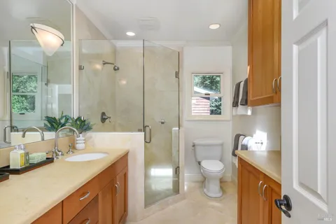 a bathroom with a granite countertop sink a toilet and shower