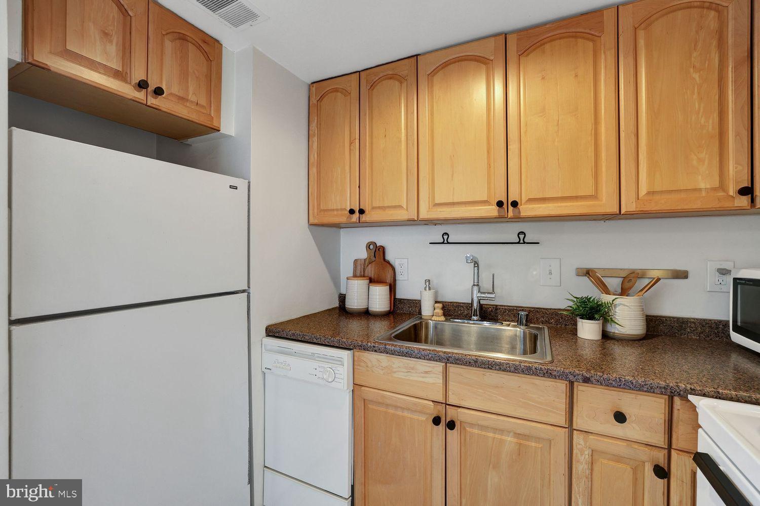 1133 13th Street Northwest, Unit 704 Washington, DC 20005 - Photo 11 of 23 a kitchen with stainless steel appliances granite countertop refrigerator sink and cabinets