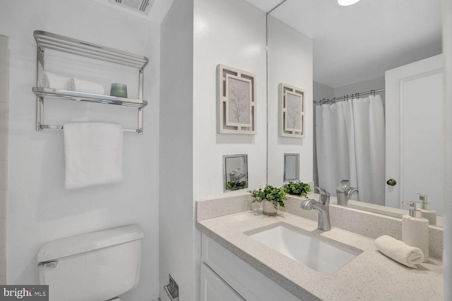 1133 13th Street Northwest, Unit 704 Washington, DC 20005 - Photo 18 of 23 a bathroom with a granite countertop sink a toilet and a mirror