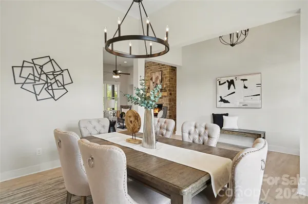 a living room with furniture kitchen view and a chandelier
