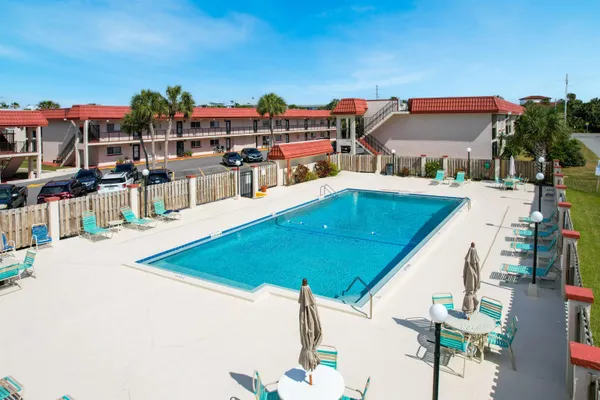 an aerial view of a house with swimming pool and seating space