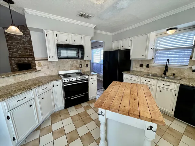 a kitchen with stainless steel appliances a stove sink microwave and cabinets