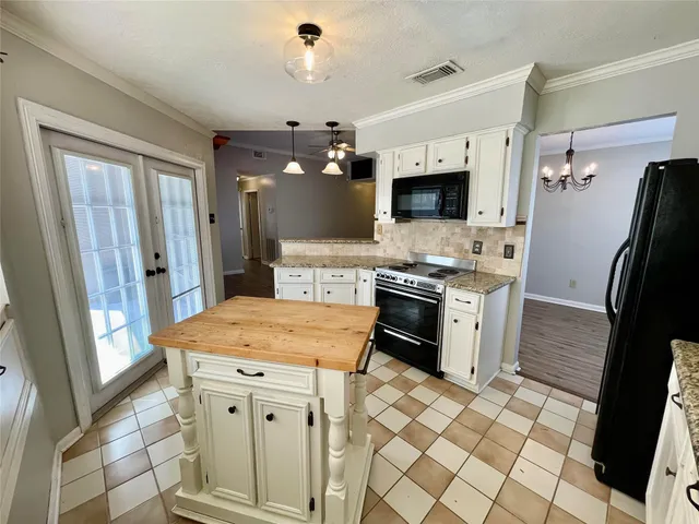a kitchen with stainless steel appliances kitchen island granite countertop a refrigerator and a stove top oven