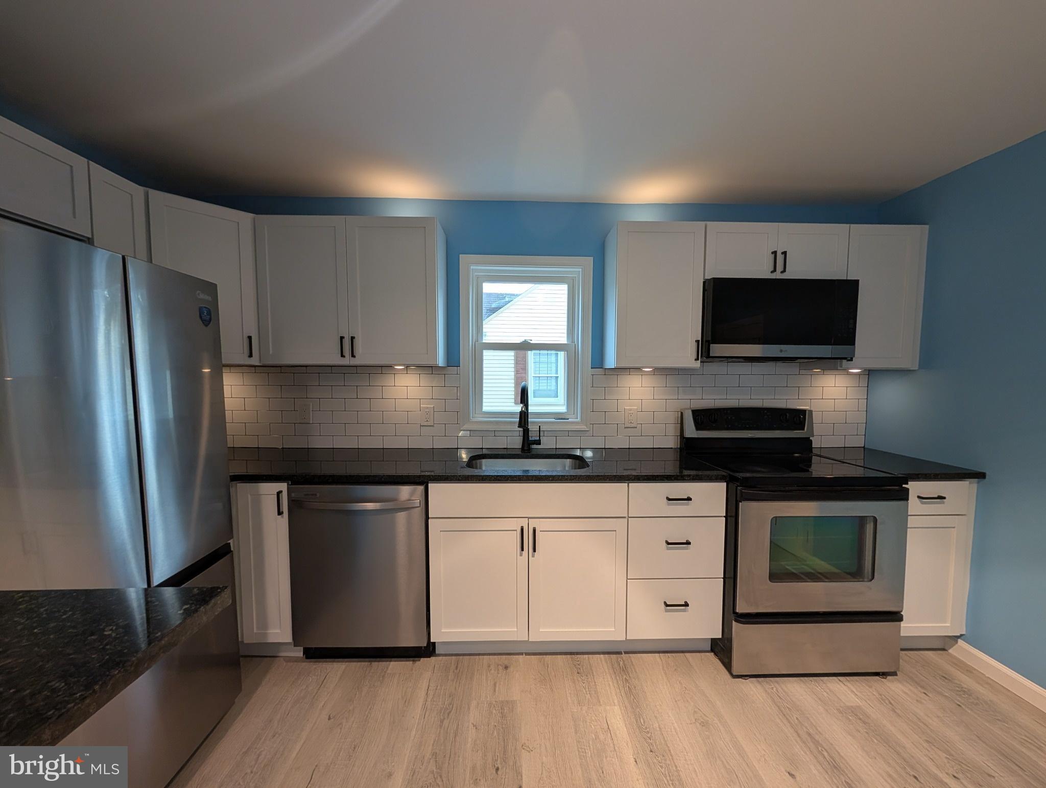 703 Madison Street Salisbury, MD 21804 - Photo 6 of 22 a kitchen with stainless steel appliances granite countertop a stove a sink and a refrigerator
