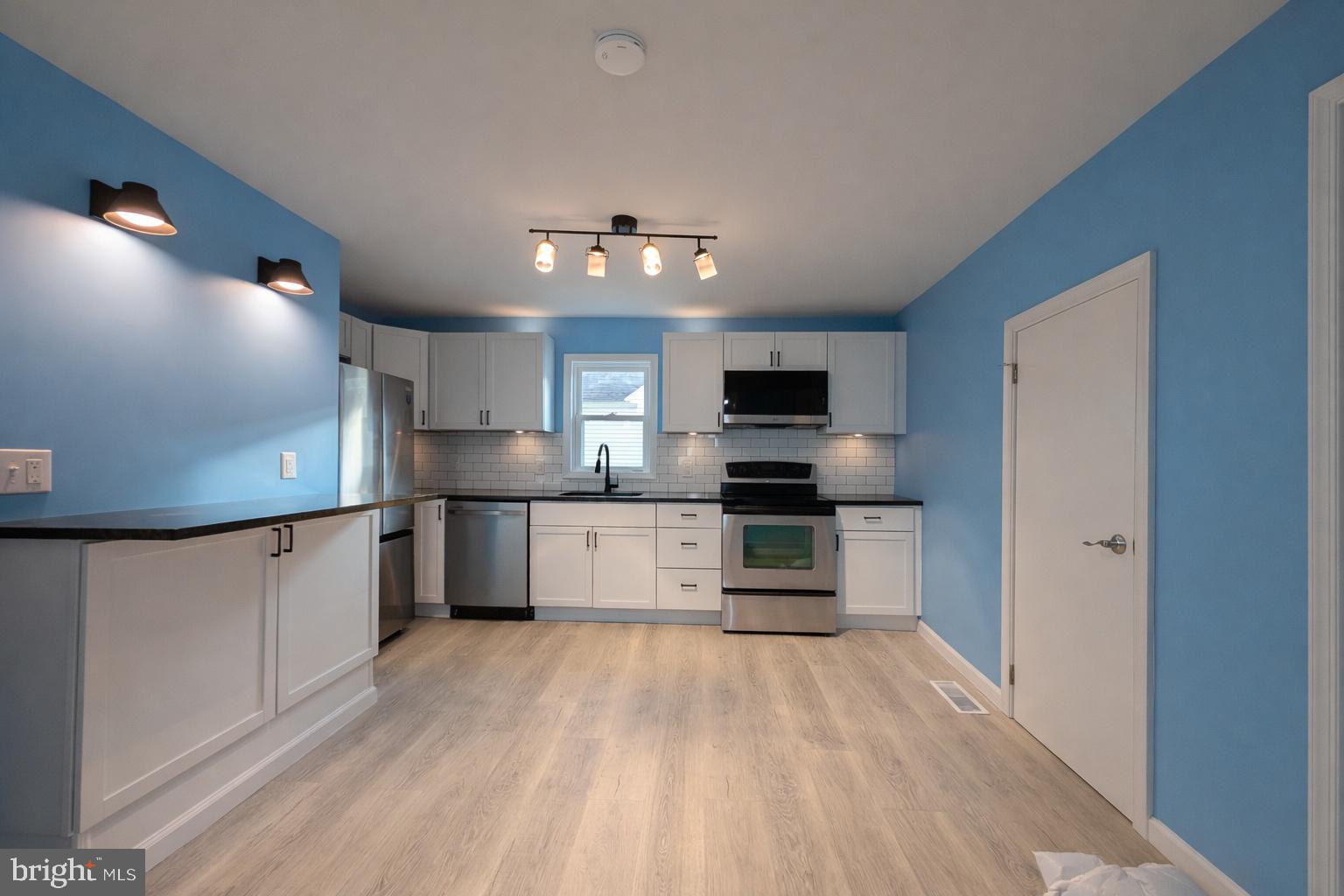703 Madison Street Salisbury, MD 21804 - Photo 8 of 22 a large kitchen with stainless steel appliances kitchen island granite countertop a stove and a sink with granite countertops