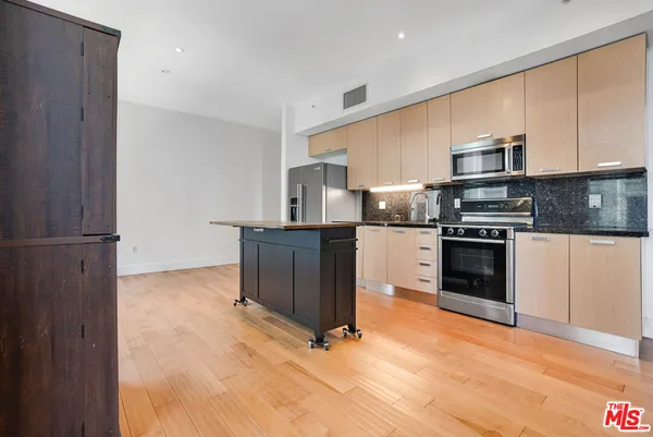a kitchen with granite countertop a stove top oven and cabinets
