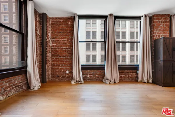 a view of an empty room with fireplace and cabinet