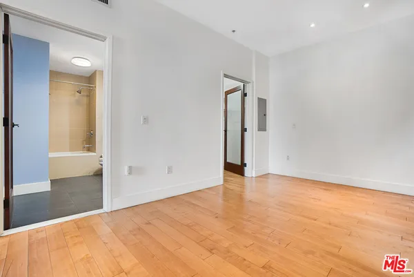 a view of an empty room with wooden floor
