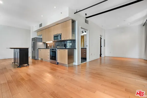 a kitchen with stainless steel appliances a refrigerator and a stove top oven