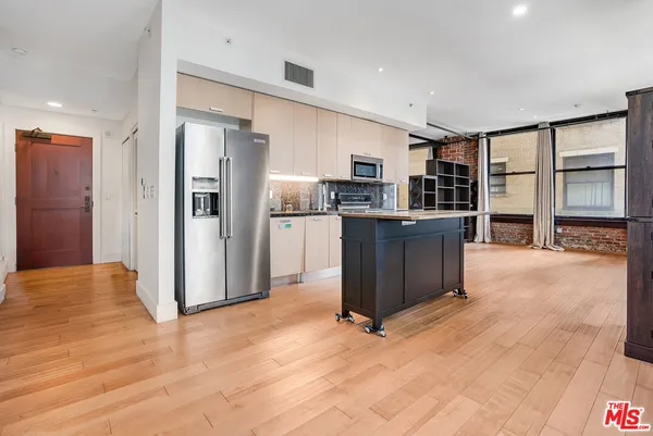 a open kitchen with stainless steel appliances granite countertop a refrigerator and a stove top oven
