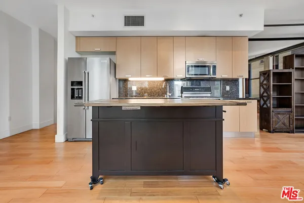 a kitchen with stainless steel appliances granite countertop a refrigerator and a sink