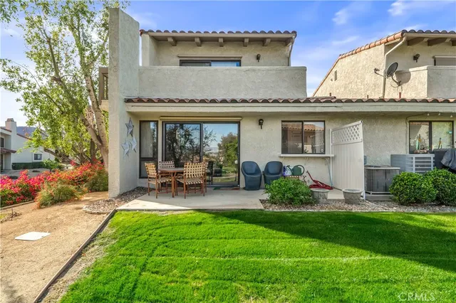 a view of a chair and table in backyard of the house