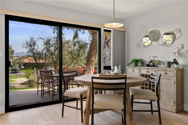 a room with lots of tables a large window and chairs