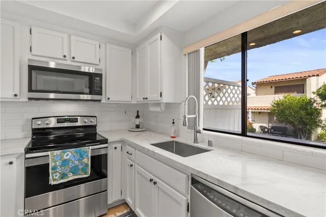 a kitchen with stainless steel appliances a sink and a refrigerator