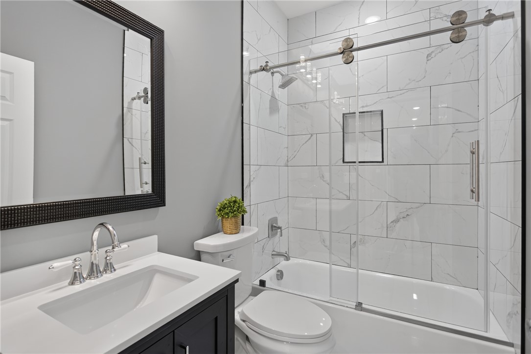 223 Maple Drive Anderson, SC 29621 - Photo 27 of 45 A well-appointed bathroom boasts a crisp vanity and a shower-tub combination with sleek glass doors.