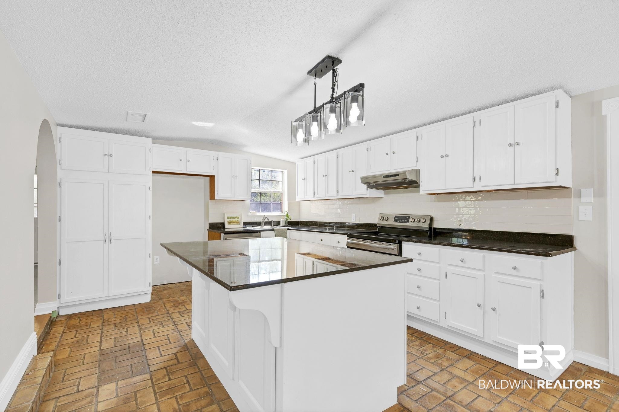 11964 Stroh Road Daphne, AL 36527 - Photo 17 of 58 Kitchen with stainless steel range with electric stovetop, white cabinets, under cabinet range hood, dark countertops, and decorative backsplash