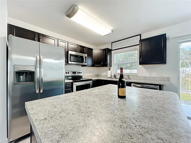 a kitchen with sink refrigerator and microwave