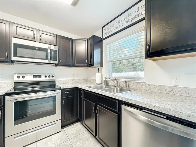 a kitchen with stainless steel appliances granite countertop a sink stove and microwave