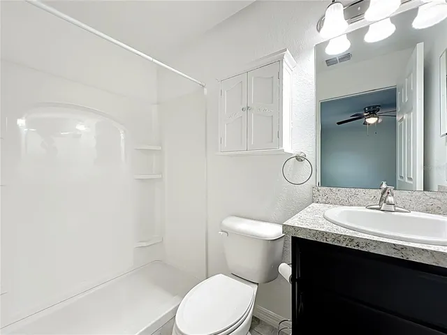 a bathroom with a sink a toilet a mirror and shower