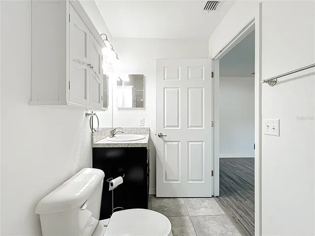 a bathroom with a sink a toilet a mirror and vanity