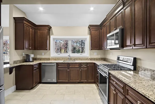 a kitchen with stainless steel appliances granite countertop a sink stove and cabinets