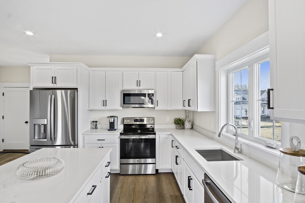 25 Salisbury Hill Boulevard, Unit 67 Worcester, MA 01609 - Photo 6 of 42 a kitchen with stainless steel appliances granite countertop a sink stove refrigerator and cabinets