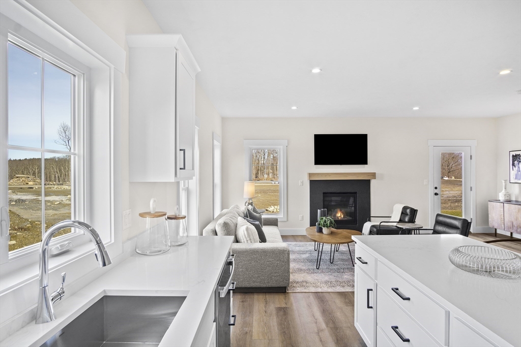 25 Salisbury Hill Boulevard, Unit 67 Worcester, MA 01609 - Photo 7 of 42 a large living room with furniture a fireplace and a large window