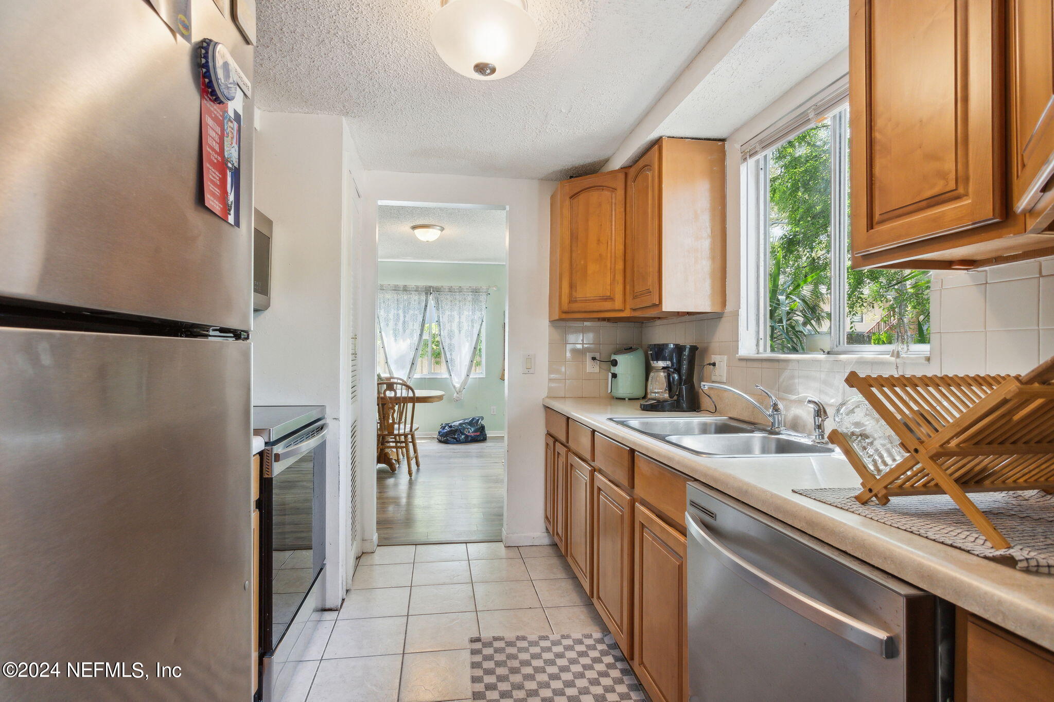 1154 Penman Road Jacksonville Beach, FL 32250 - Photo 7 of 20 a kitchen with stainless steel appliances granite countertop a refrigerator and a sink