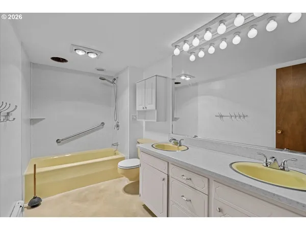 a bathroom with a granite countertop sink mirror toilet and bathtub