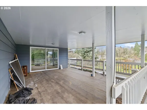 a view of an empty room with wooden floor and windows