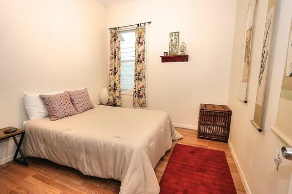 a bedroom with a bed and wooden floor