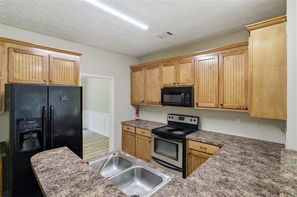 1231 Hillview Road Hampton, GA 30228 - Photo 9 of 49 a kitchen with granite countertop a stove a sink and a refrigerator