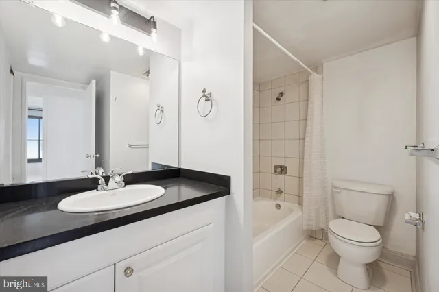 a bathroom with a granite countertop sink a toilet and a mirror