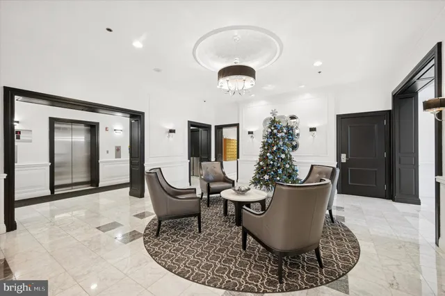 a living room with furniture a chandelier and a glass door